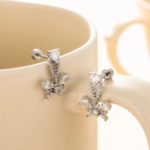 Silver butterfly zircon heart pendant earrings on ceramic cup rim professional shot