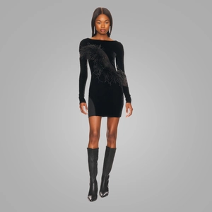 Detail of elegant black velvet mini dress featuring luxurious feather trim and slim fit