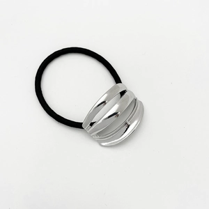 Detail of high-elastic black ponytail holder with a polished silver metallic layered ornament