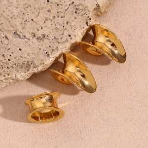 Détail de boucles d'oreilles créoles courbées en acier inoxydable plaqué or 18K avec rainures