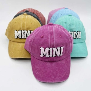 Detailed pile of washed cotton baseball caps with MINI embroidery in multiple colors