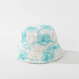 Detail shot of 3D blue and white plush roses on a textured winter bucket hat for women