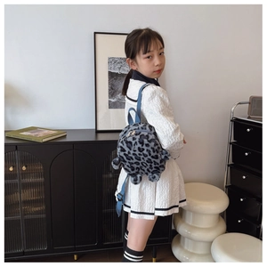 Blue leopard print plush toddler backpack shown on a child in a home setting