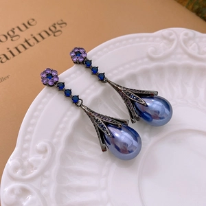 Macro shot of vintage floral drop earrings with blue pearls and purple crystals