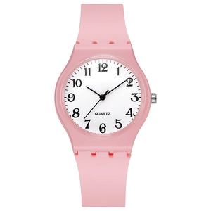 Detailed view of pink silicone watch with white dial and black Arabic numerals