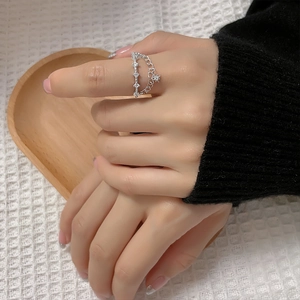Detail of silver double-layered ring with star pendant and zircons on woman's finger
