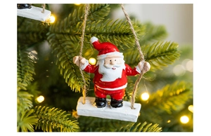 Close-up of Santa Claus on a wooden swing hanging from a Christmas tree branch