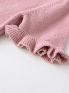 Close-up of pink knit sweater showing soft brushed texture and ruffle edge detail