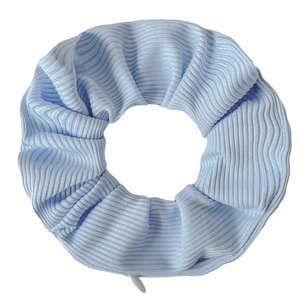 Detail shot of light blue ribbed knit fabric hair scrunchie on a white background