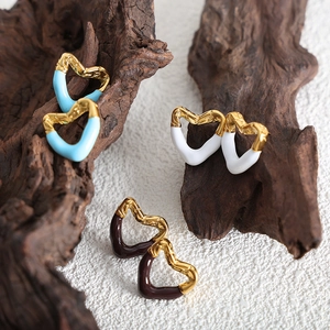 Golden heart earrings with colorful enamel dripping oil on a natural tree bark background
