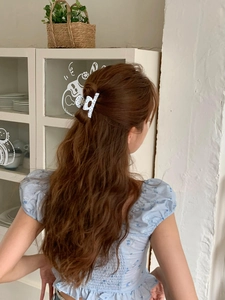 Polka dot acetate hair claw clip shown on brunette hair for a stylish half-up hairstyle