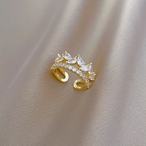 Gold adjustable ring with marquise cut cubic zirconia on champagne silk background