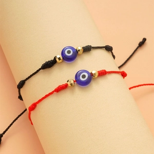 Dettaglio di braccialetti fatti a mano Evil Eye con cordini intrecciati rossi e neri