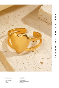 Détail d'une bague double couche en or 18 carats avec cœur sur fond de pierre