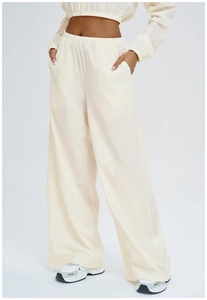 Detail of cream white high-waisted wide-leg pants with elastic drawstring waist and side pockets