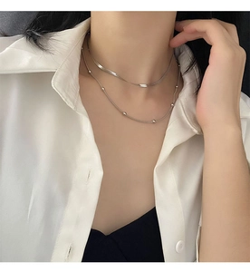 Silver double layer necklace featuring flat snake chain and bead chain on model