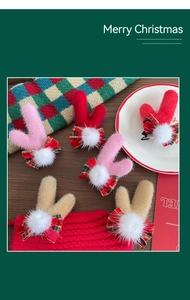 Détail de pinces à cheveux bois de renne en peluche avec nœuds à carreaux pour Noël