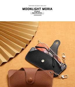Detail of lychee pattern leather sunglass pouch with gold chain and snap closure
