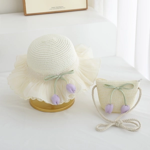 Detail of girl's straw hat and matching bag with purple tulip charms and green ribbon