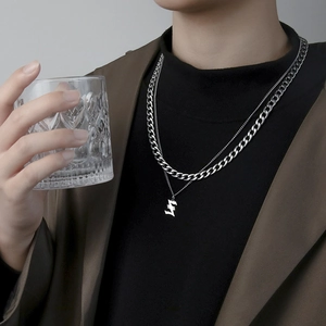 Double layered silver Cuban chain necklace with Gothic letter S pendant on male model