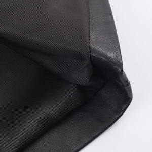 Gros plan détaillé sur la texture du simili cuir et la doublure en sergé noir du manteau