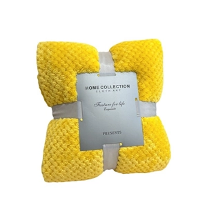 Yellow pineapple grid flannel blanket folded with a gray home collection gift ribbon