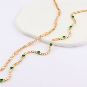 Detailed close-up of gold tennis necklaces with micro-pave white, green and pink zircons