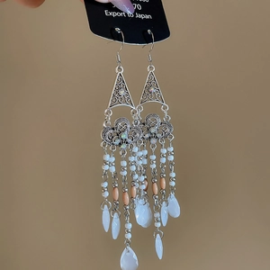 Detailed view of bohemian teardrop earrings with multi-layer bead tassels and floral patterns