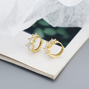 Close-up of gold plated 925 silver hoop earrings featuring three sparkling zircons