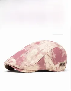Detail view of red tie-dye vintage flat cap with GSIOR side logo on cotton fabric