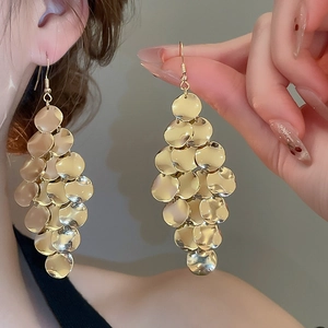 Detailed view of layered gold circular sequins forming a diamond-shaped drop earring