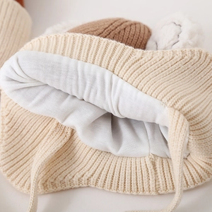 Beige knit baby hat with warm white fleece lining and cute pom-pom ears for toddlers