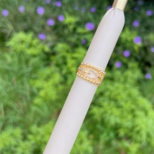 Close-up of 18K gold-plated braided ring with horseshoe horsebit and pavé zircon stones