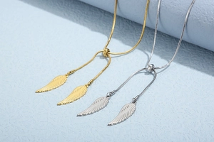 Detail of gold and silver angel wing pendants on adjustable snake chains with S925 stamp