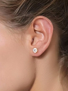 Close-up of a classic moissanite stud earring with a gold base on a woman's ear