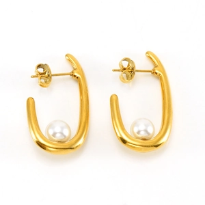 Gros plan sur les boucles d'oreilles dorées en U en acier inoxydable et perles blanches