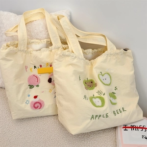 Close-up of cute dog and fruit embroidery on canvas tote bags in a cozy home setting