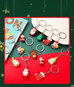 Detail view of colorful PVC Christmas keychains featuring Santa, trees, and reindeer