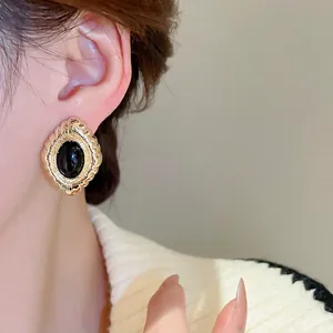 Elegant gold oval stud earrings with vintage floral relief and black gemstone for women