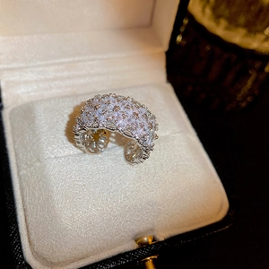 Close-up of sparkling zircon flower open ring with intricate hollow engraving details