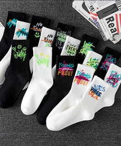 Detail of stacked cotton sports socks with graffiti prints like SUNNY and YOUNG AND FREE