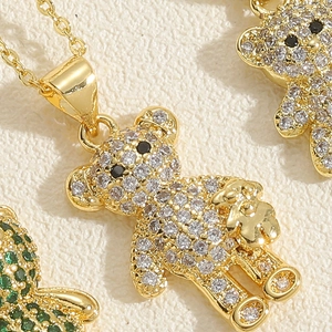 Macro shot of gold bear pendant necklace with pave-set white zircons and black gemstone eyes