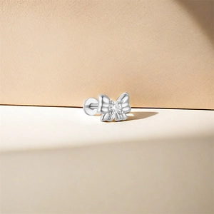 Macro detail of a 925 sterling silver bow labret stud with a clear zircon stone