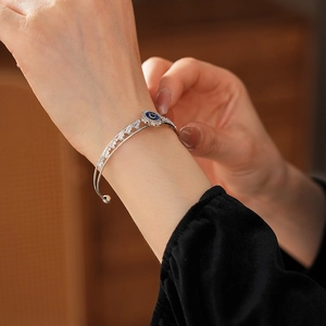 Dettaglio del bracciale occhio portafortuna con zircone blu e pietre pavé al polso