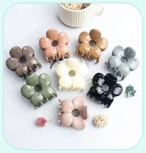 Detail view of eight colorful glossy flower hair claws in diverse Morandi tones
