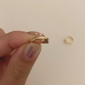 Close-up of a gold sterling silver hoop earring with sparkling cubic zirconia stone