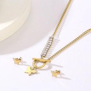 Detail of gold butterfly necklace and studs set with rectangular cubic zirconia