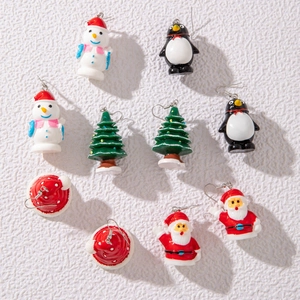 Macro detail of Christmas themed earring set featuring snowman penguin and tree