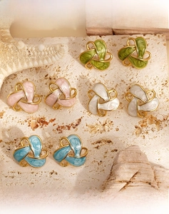 Detail of 316 stainless steel enamel flower earrings on natural stone with seashells