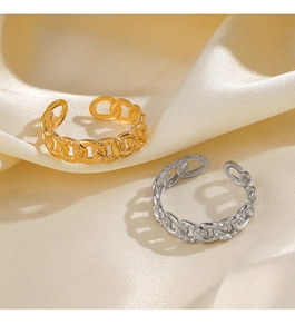 Detail view of gold and silver chain link rings on elegant beige satin fabric texture